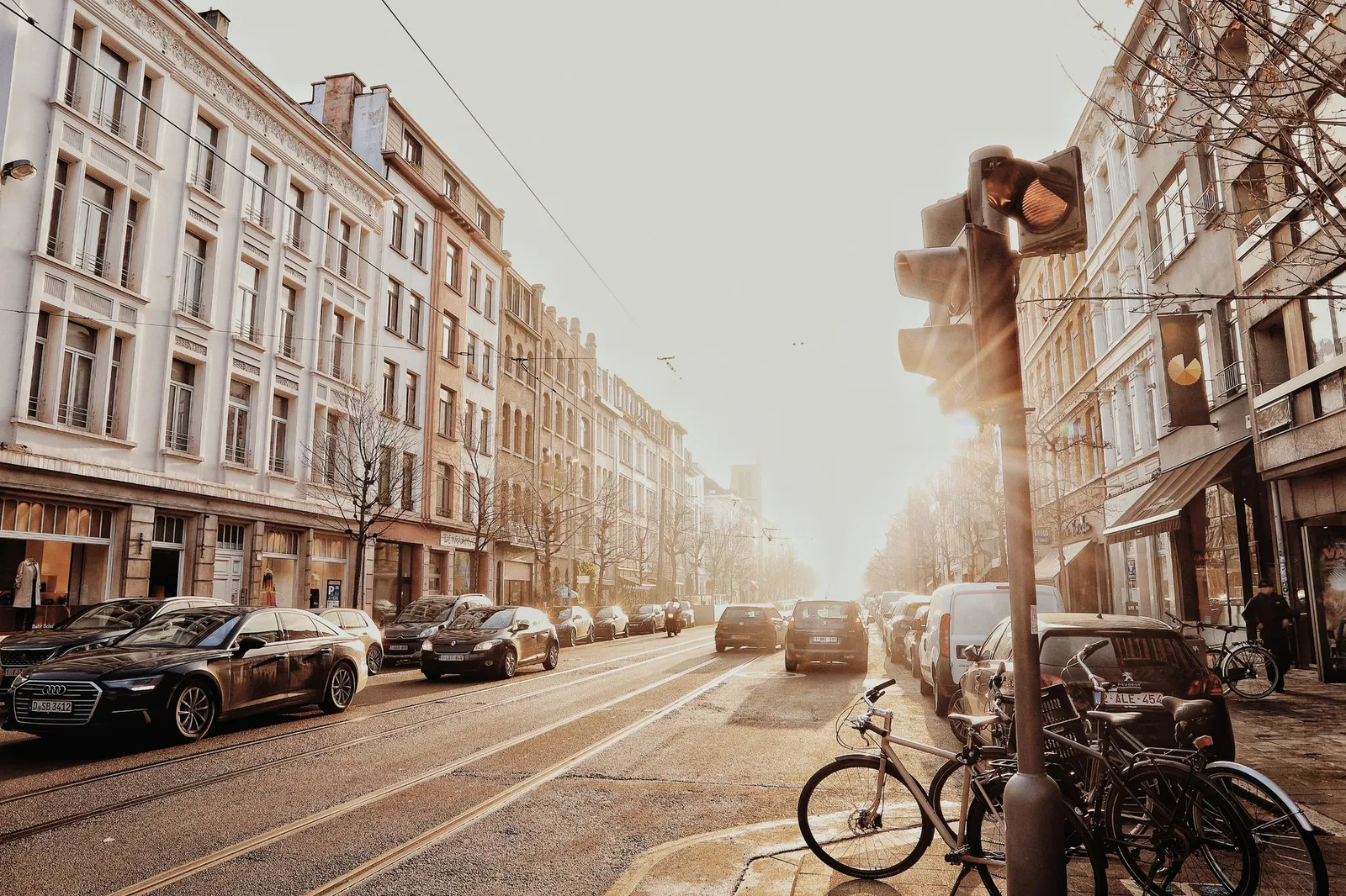 A vibrant street scene in Antwerp, Belgium, showcasing urban architecture and bustling morning traffic.