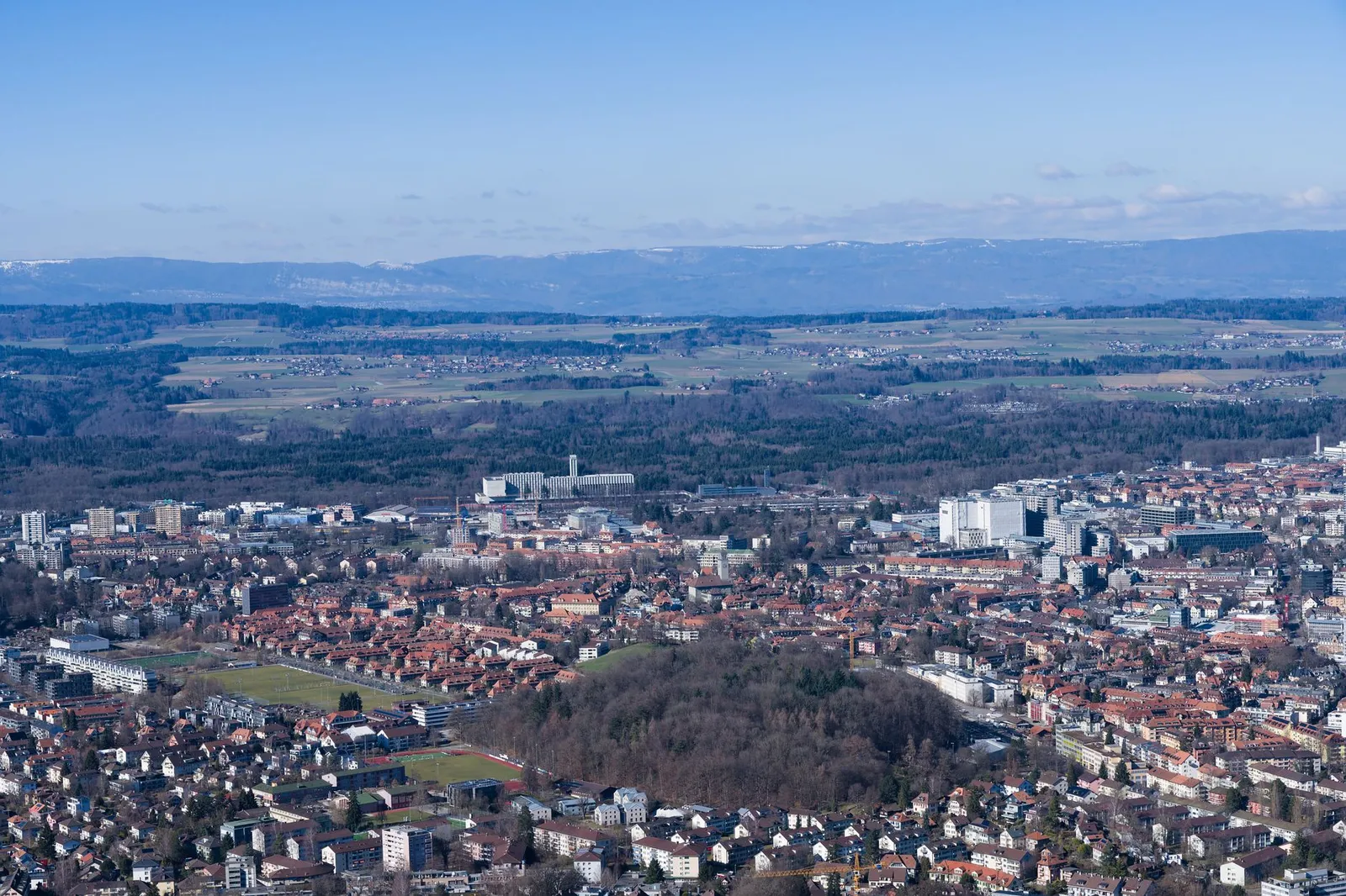 A breathtaking aerial view of Bern, Switzerland's cityscape with distant mountains.