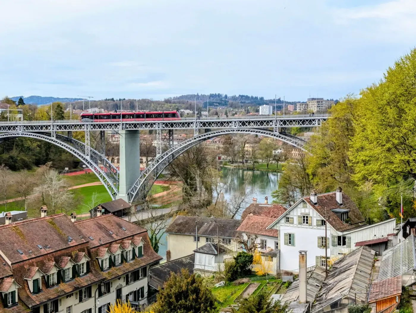 Picturesque scene of the Kirchenfeld Bridge and Aare River with a train in Bern, Switzerland.