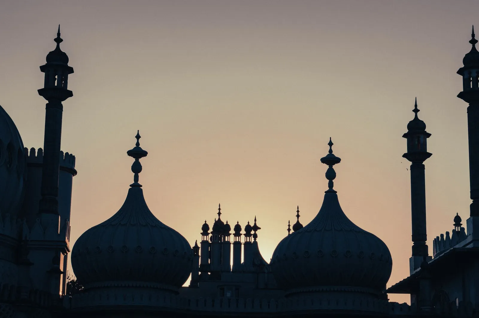 Capturing the iconic Royal Pavilion domes silhouetted against a vibrant sunset sky in Brighton, UK.