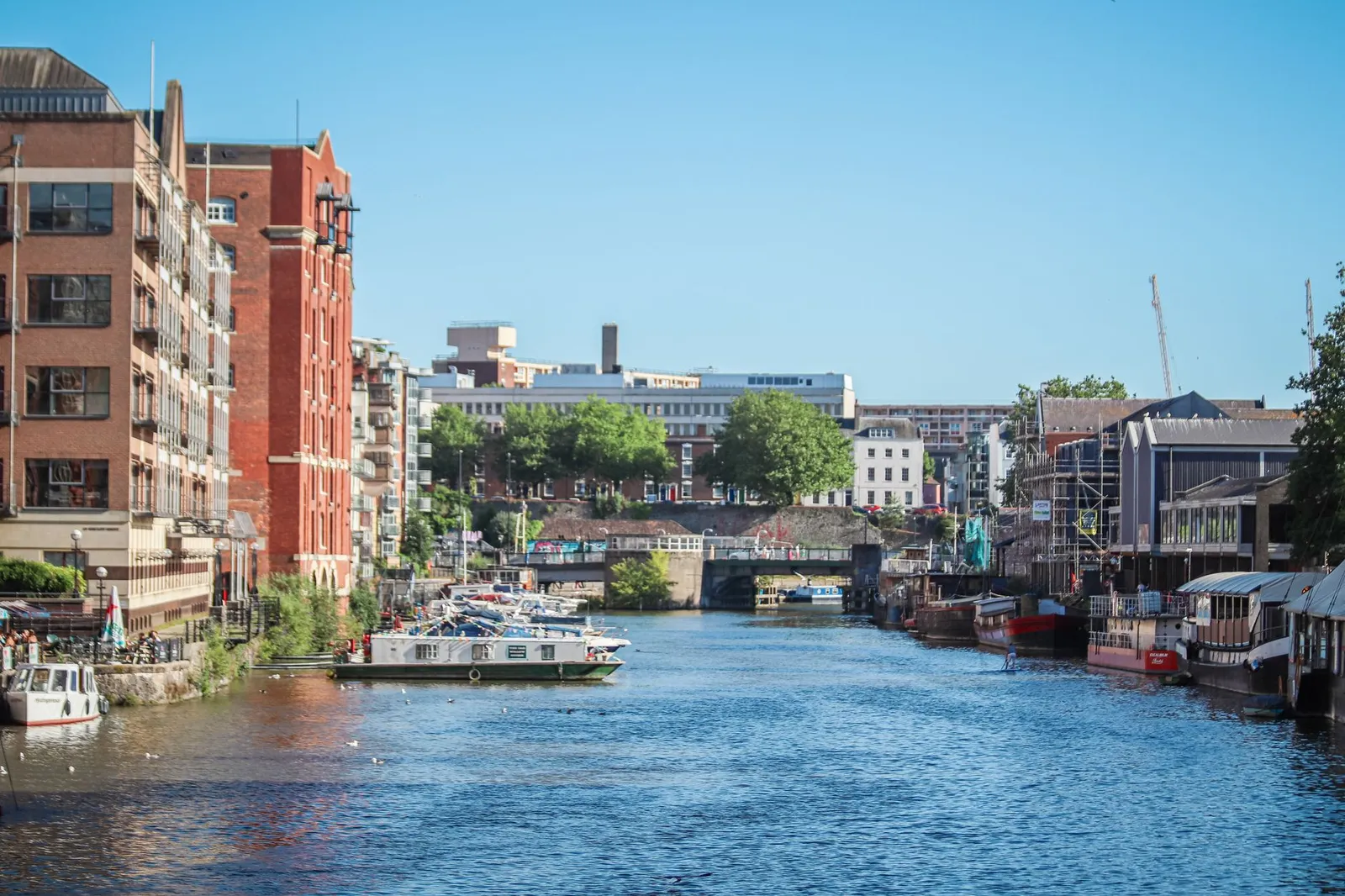 Beautiful view of a canal surrounded by buildings and boats in Bristol, England.