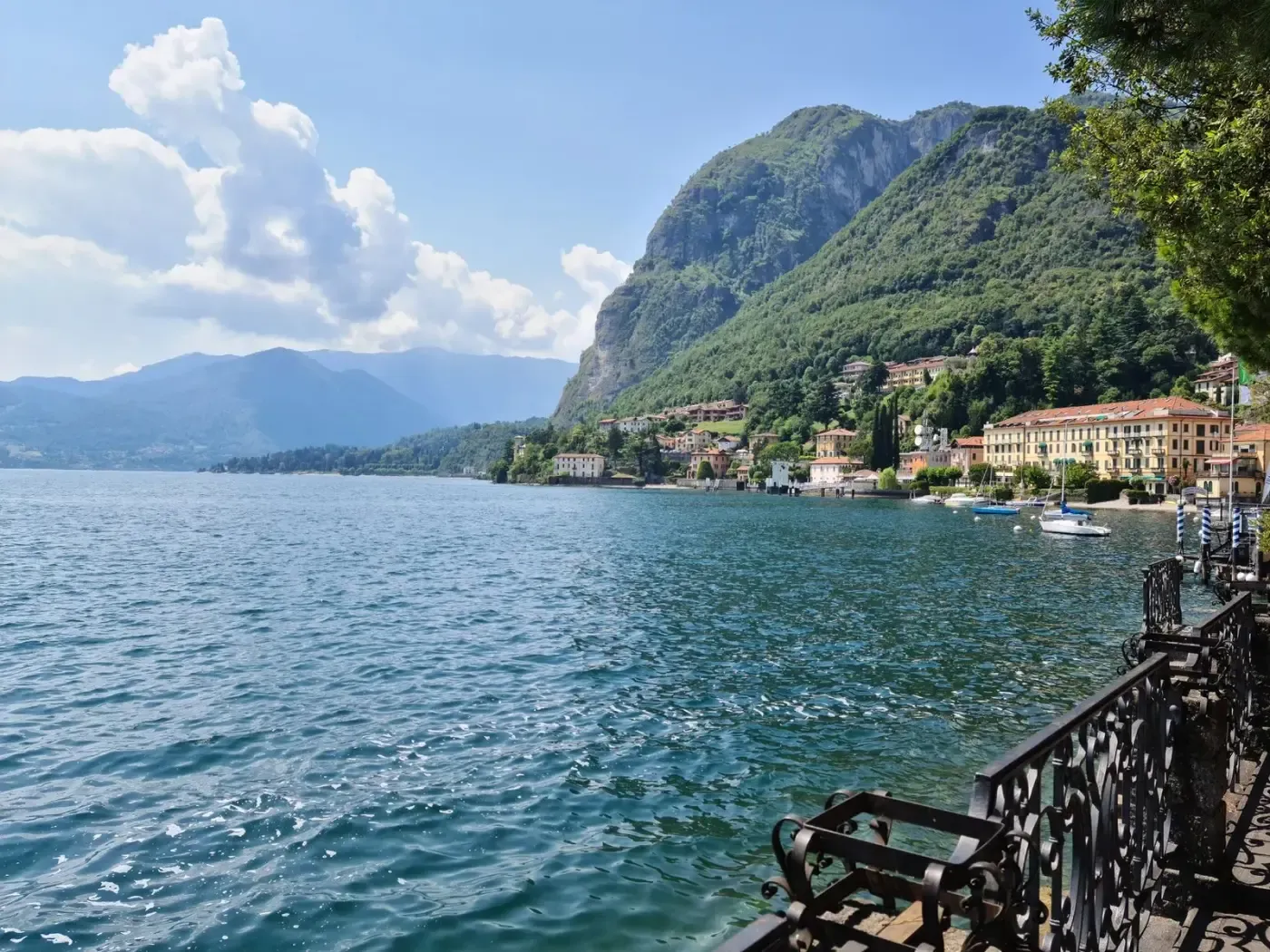 Tranquil view of Lake Como with lush mountains and charming Italian architecture in Lombardy.