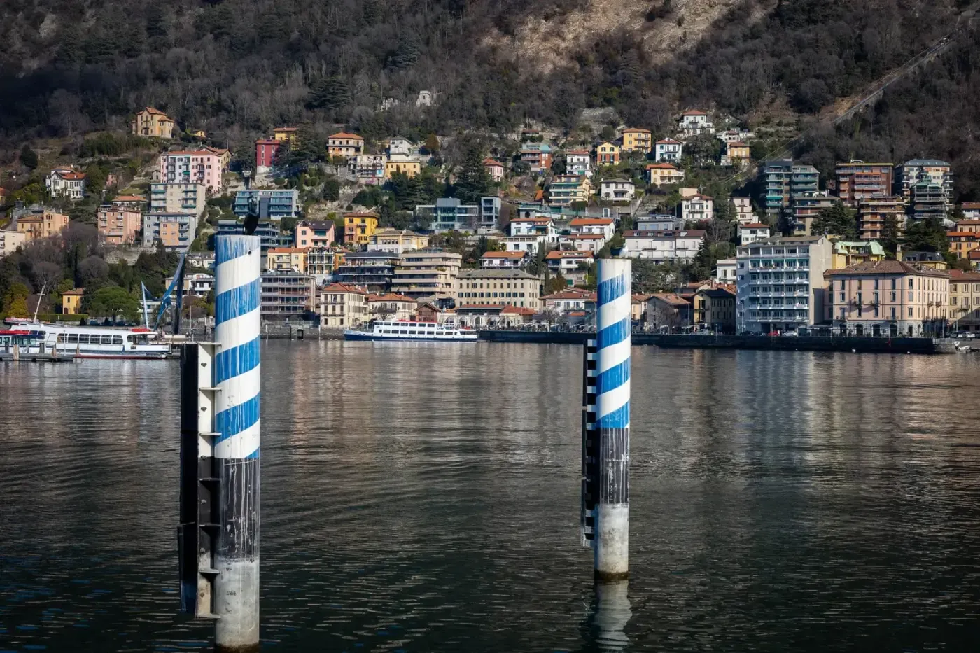 Scenic view of colorful houses along Lake Como with boats and waterfront elements.