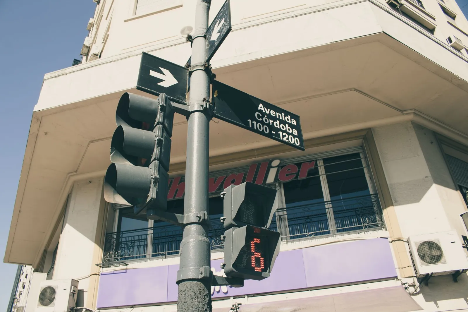 Low angle shot of a traffic light and street sign on Avenida Córdoba, Buenos Aires.
