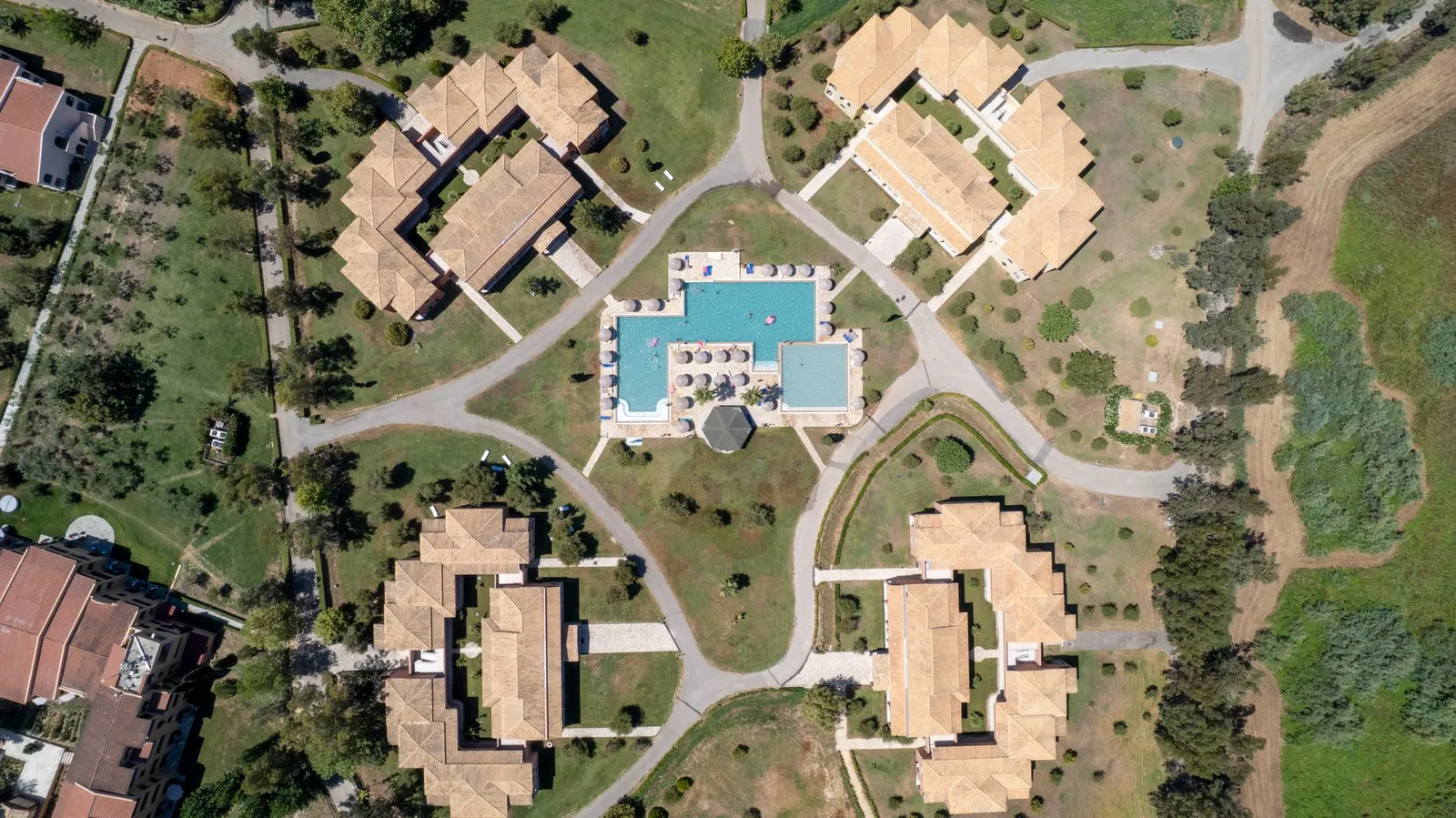 Stunning aerial shot of a sunlit resort in Corfu, capturing its architectural layout and greenery.