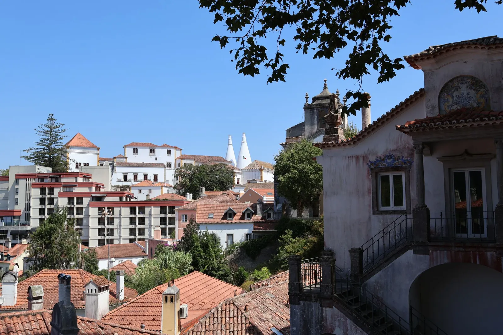Beautiful view of Sintra's traditional architecture with a clear blue sky backdrop, showcasing historic charm and tiled rooftops.