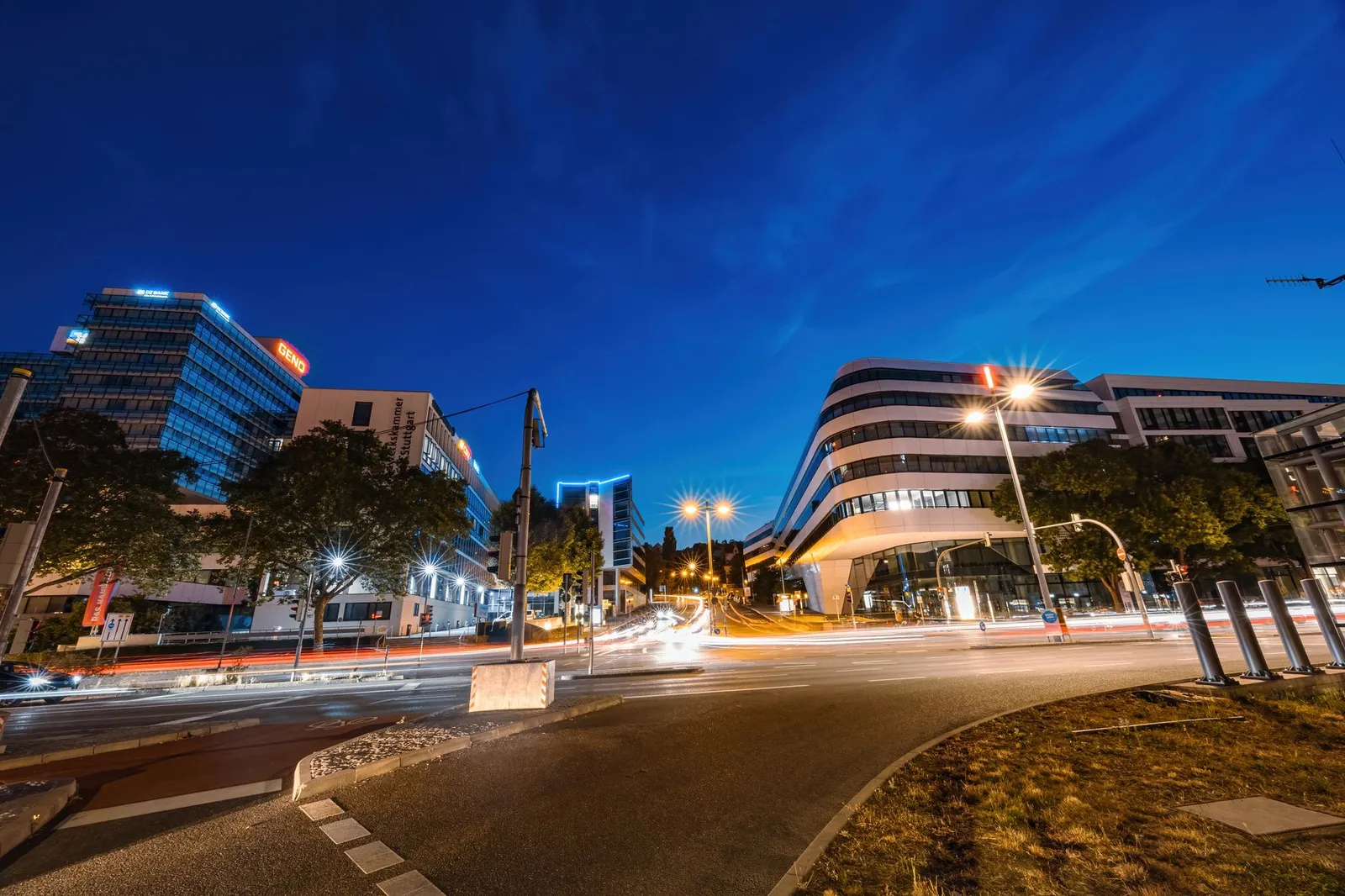 A vibrant city street in Stuttgart, Germany, captured at dusk with dynamic light trails and modern architecture.