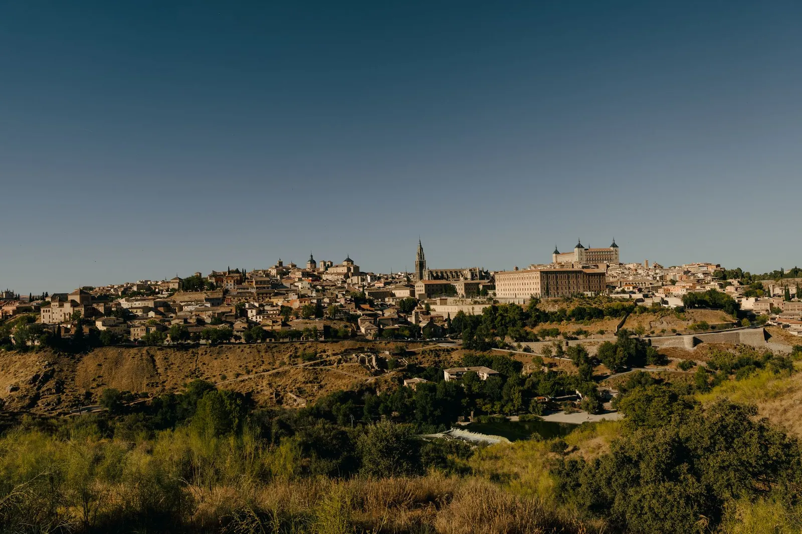 Panoramic view of the historic city of Toledo, showcasing its stunning architecture under a clear blue sky.