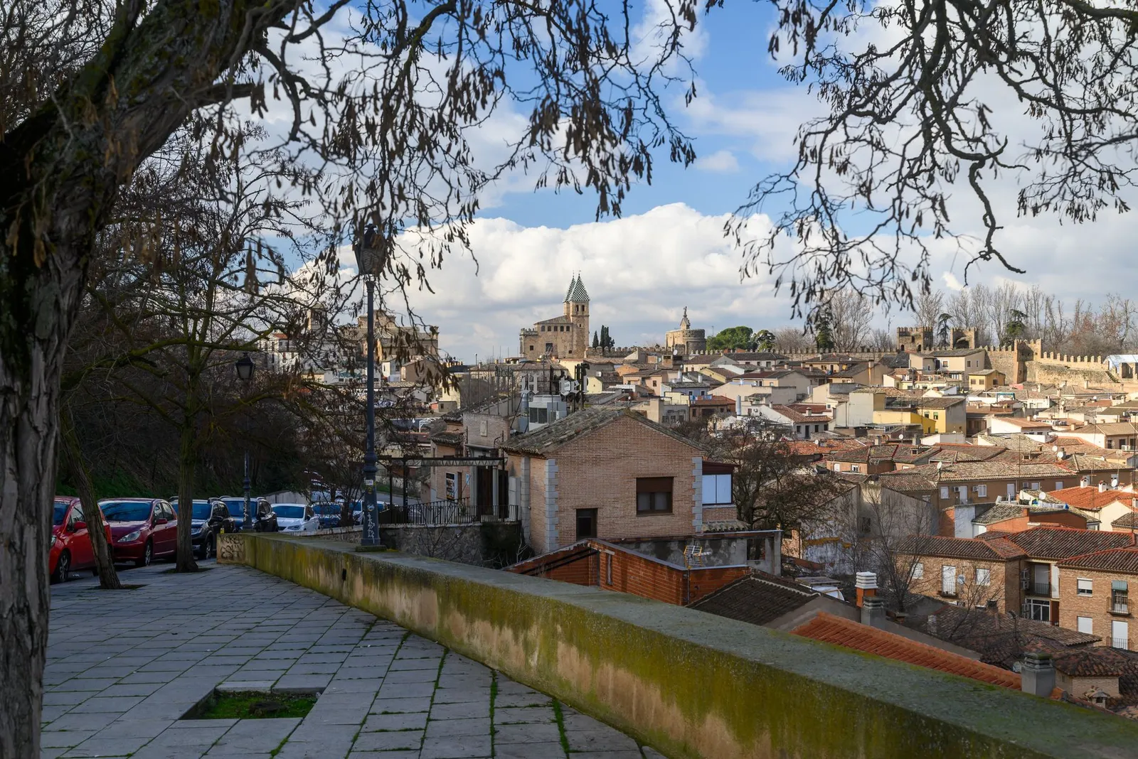 Explore the stunning view of historic Toledo, Spain with its iconic architecture under a bright sky.