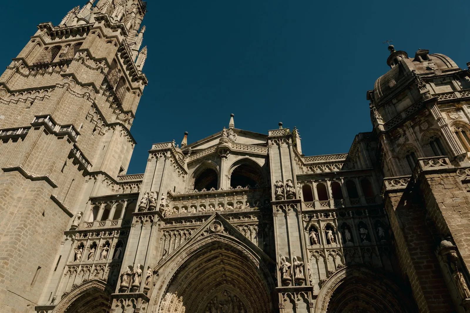 Stunning view of Toledo Cathedral's ornate exterior, highlighting Gothic architecture against a clear sky.