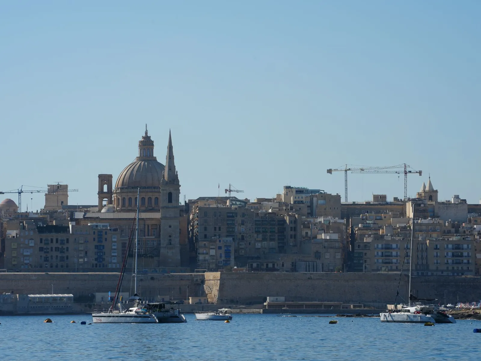 Beautiful view of Valletta with boats in foreground, highlighting iconic architecture under a clear blue sky.